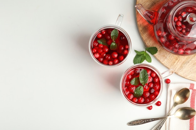 Tasty hot cranberry tea and fresh ingredients on light table flat lay Space for text