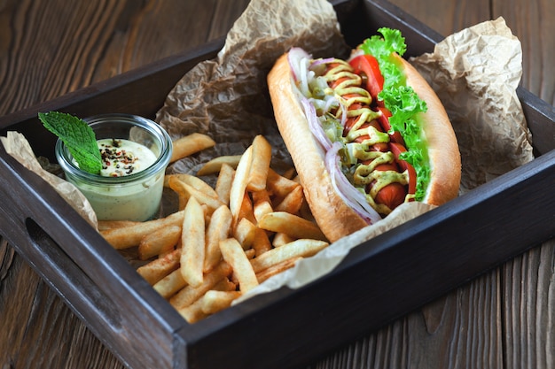 Tasty hot dog with sausage and fries