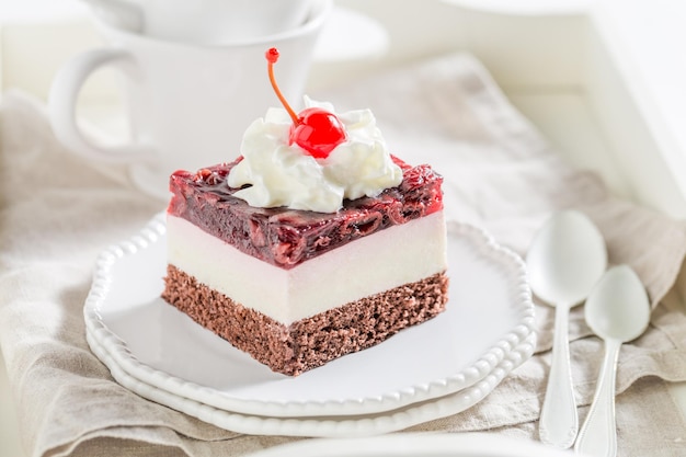 Tasty jelly cherry cake with cream and cherries