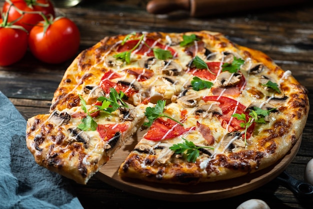 Tasty juicy pizza on wooden background. lots of meat and cheese. Mushroom pizza. Pepperoni pizza. Mozzarella and tomato. Italian dish. Italian food. Comfort food. Local food