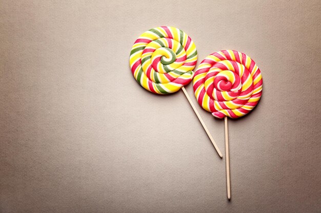 Tasty lollipops on color background