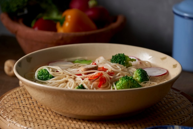 Tasty meat broth with noodles, broccoli and parsley in a bowl