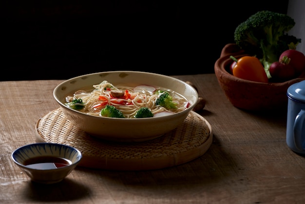 Tasty meat broth with noodles, broccoli and parsley in a bowl