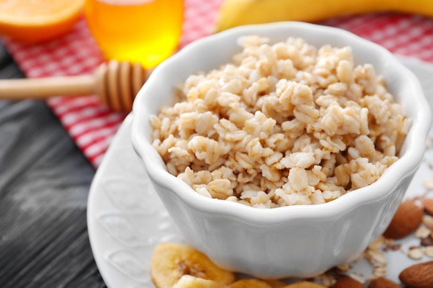 Tasty oatmeal in bowl for breakfast on table