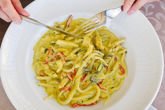 Tasty pasta with sauce in white bowl flat lay top view eating in restaurant