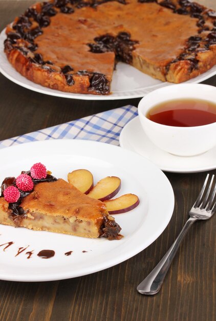 Tasty pie on plate on wooden table