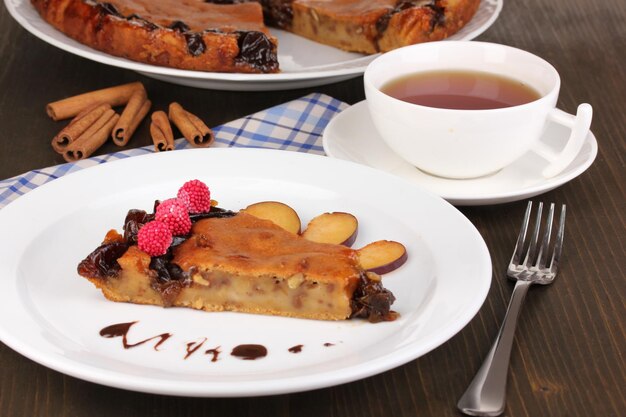 Tasty pie on plate on wooden table