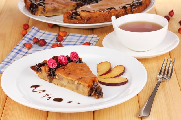 Tasty pie on plate on wooden table