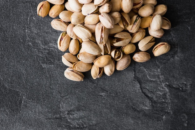 Tasty pistachio nuts on dark background