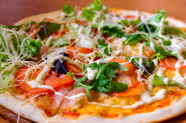 Tasty pizza with arugula, tomatoes and bacon