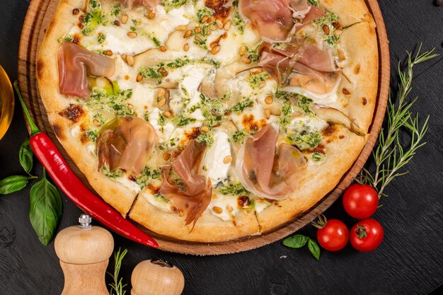 Tasty pizza with philadelphia cheese and ham on wooden background