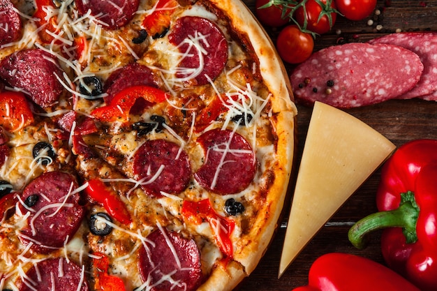 Tasty pizza with salami served on wooden table