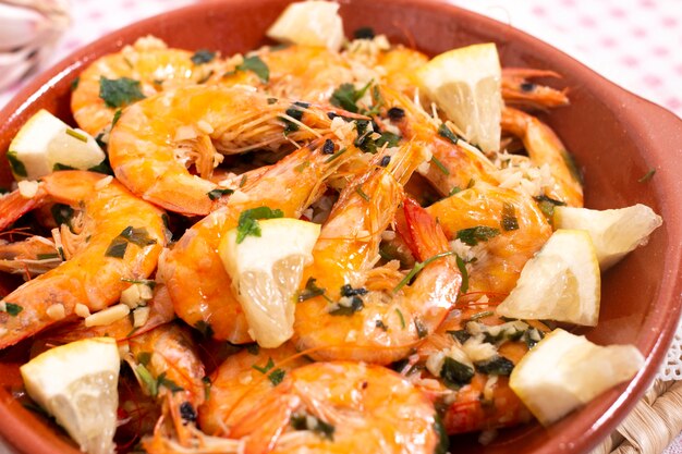 Photo tasty portuguese meal with fried shrimps, seasoned with garlic, olive oil and parsley, served with toasted bread.