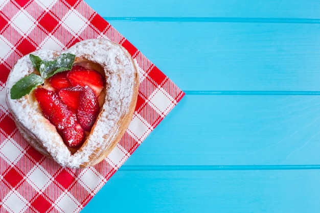 Tasty puff pastry with strawberries on a blue background