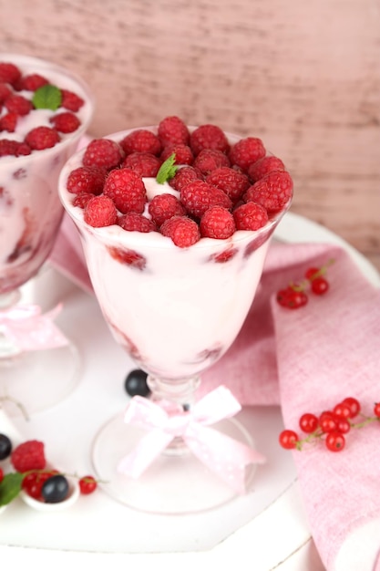 Tasty raspberry dessert with berries on pink wooden background