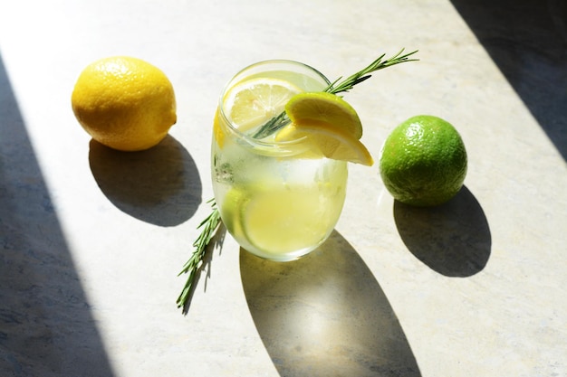 Tasty refreshing lemonade and ingredients on light table Summer drink