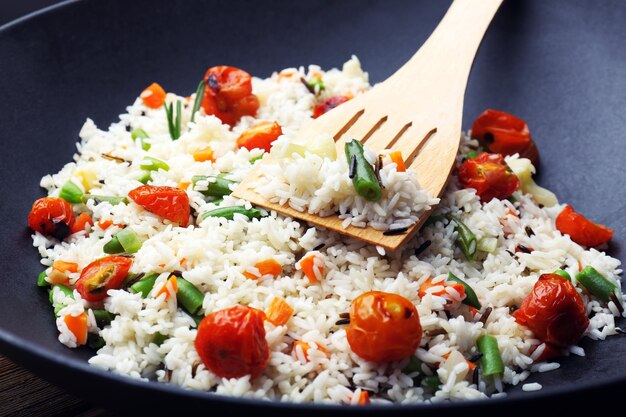 Tasty rice preparing in wok closeup