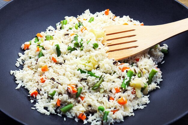 Tasty rice preparing in wok closeup