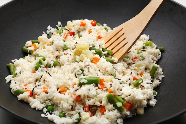 Tasty rice preparing in wok closeup