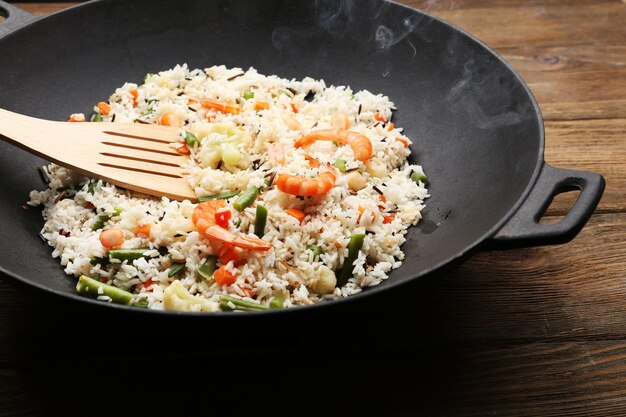 Tasty rice preparing in wok closeup