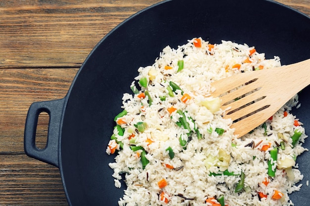 Tasty rice preparing in wok closeup