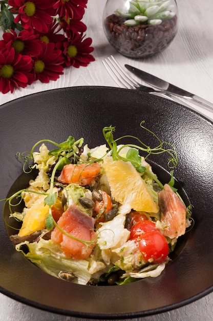 Tasty salad with salmon vegetables and oranges