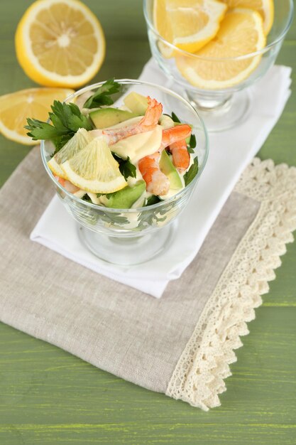 Tasty salad with shrimps and avocado on wooden background