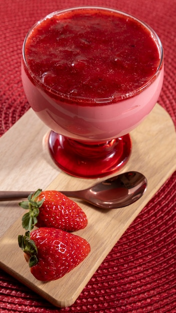 Tasty strawberry mousse in glass with jam on top.