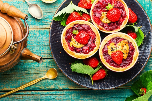 Photo tasty tartlets with berry jam.cake with strawberries.sweets for tea