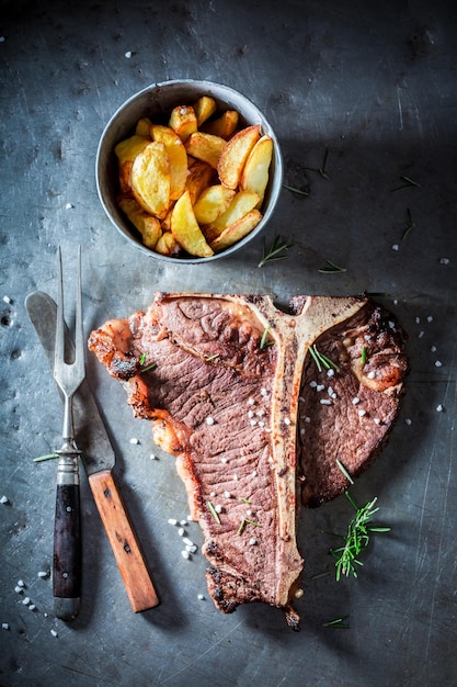 Tasty tbone steak and chips with salt and rosemary