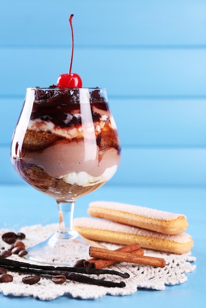 Photo tasty tiramisu dessert in glass on color wooden background