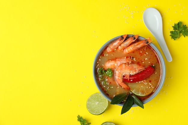 Tasty Tom yum soup on yellow background