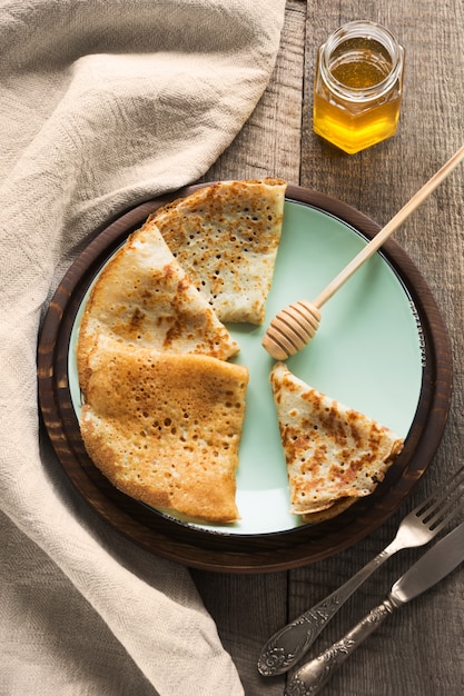 Tasty traditional russian breakfast of slapjack with honey on plate. 