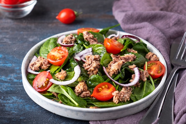 Tasty tuna salad with tomatoes, red onion and spinach.