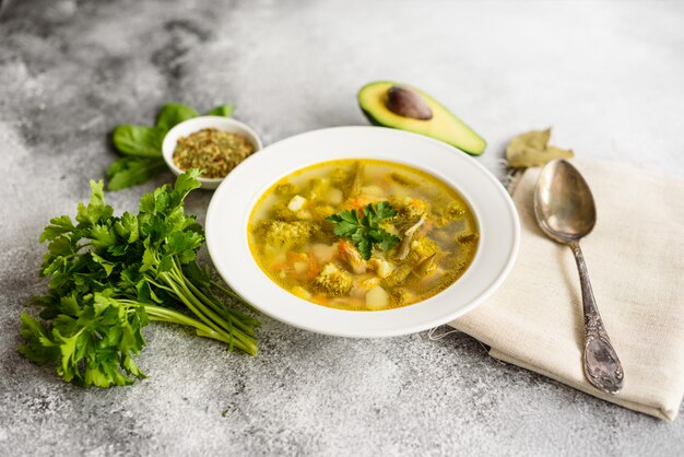 Tasty vegetables and spices soup on a gray concrete background