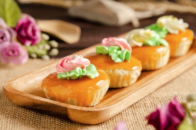 tasty vintage cupcakes on wooden tray with flowers