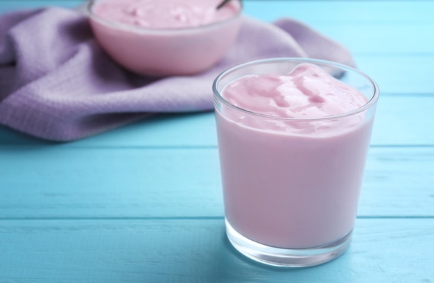 Tasty yogurt in glass on wooden table