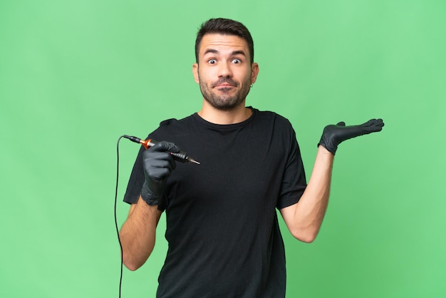 Tattoo artist caucasian man over isolated background having doubts while raising hands