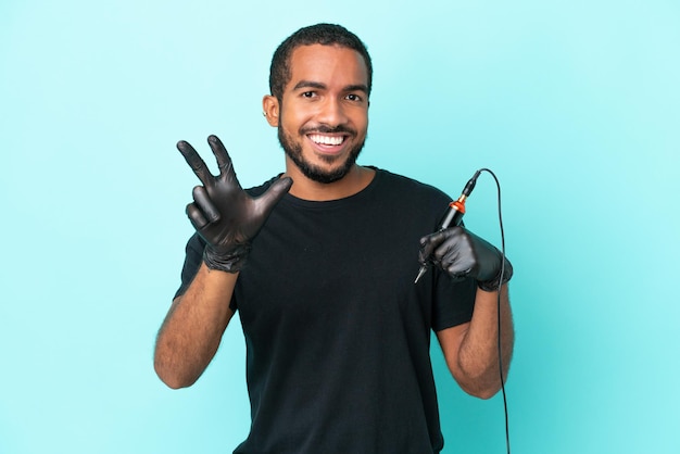 Tattoo artist Ecuadorian man isolated on blue background happy and counting three with fingers