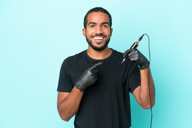 Tattoo artist Ecuadorian man isolated on blue background pointing to the side to present a product