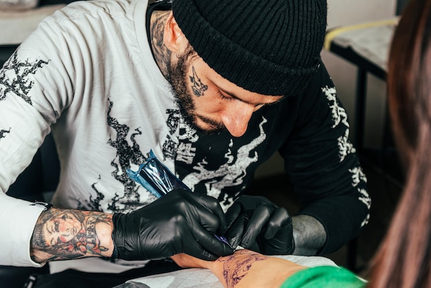 A tattoo artist makes a tattoo in a salon