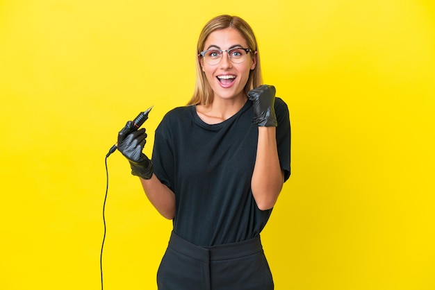 Tattoo artist Uruguayan woman isolated on yellow background celebrating a victory in winner position