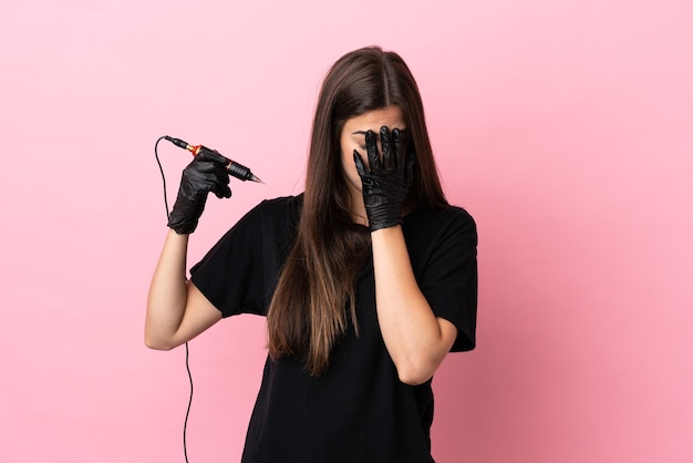 Tattoo artist woman isolated on pink background with tired and sick expression