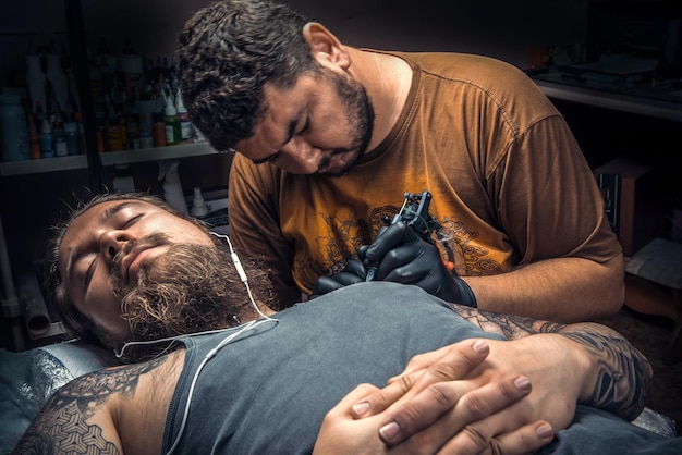 Tattoo artist at work in salon./Professional tattooist posing in tattoo studio.