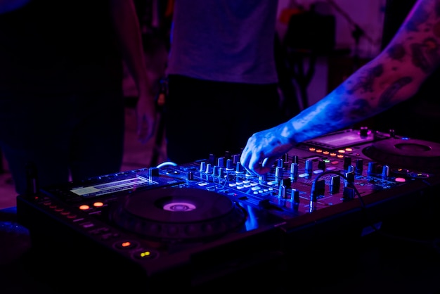 Tattooed hand on a sound mixer station