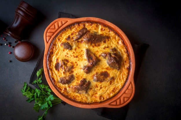 Tave kosi is a national Albanian dish of baked lamb and rice with yoghurt close-up in a pan on the table. horizontal top view from above. Turkish name; Elbasan tava