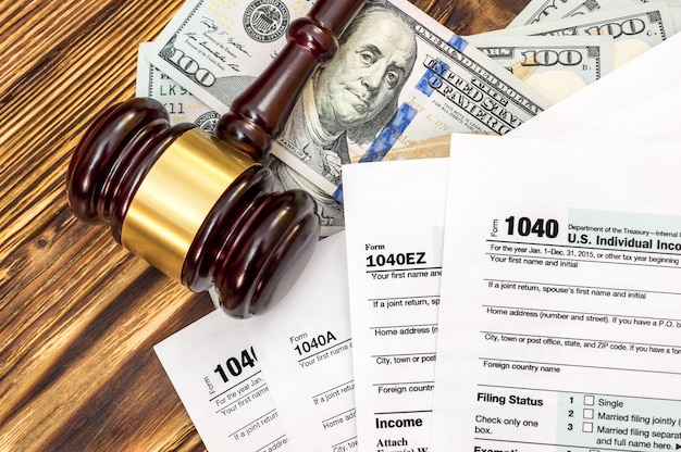 Tax forms judge's gavel and dollars on the wooden desk Business background