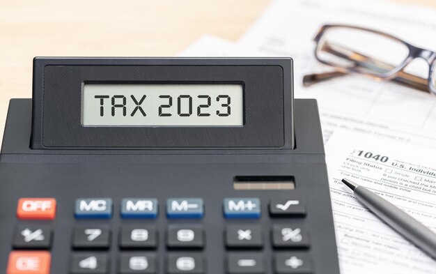 Tax time 2023 concept Text on calculator screen and tax form on table