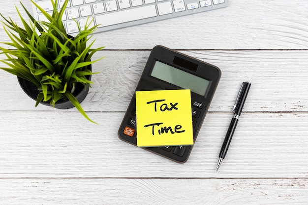 Tax time text on adhesive note on top of office desk