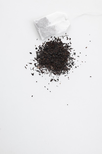 Tea bag on a white background Tea bag on a pile of loose tea Fast and convenient way to brew tea